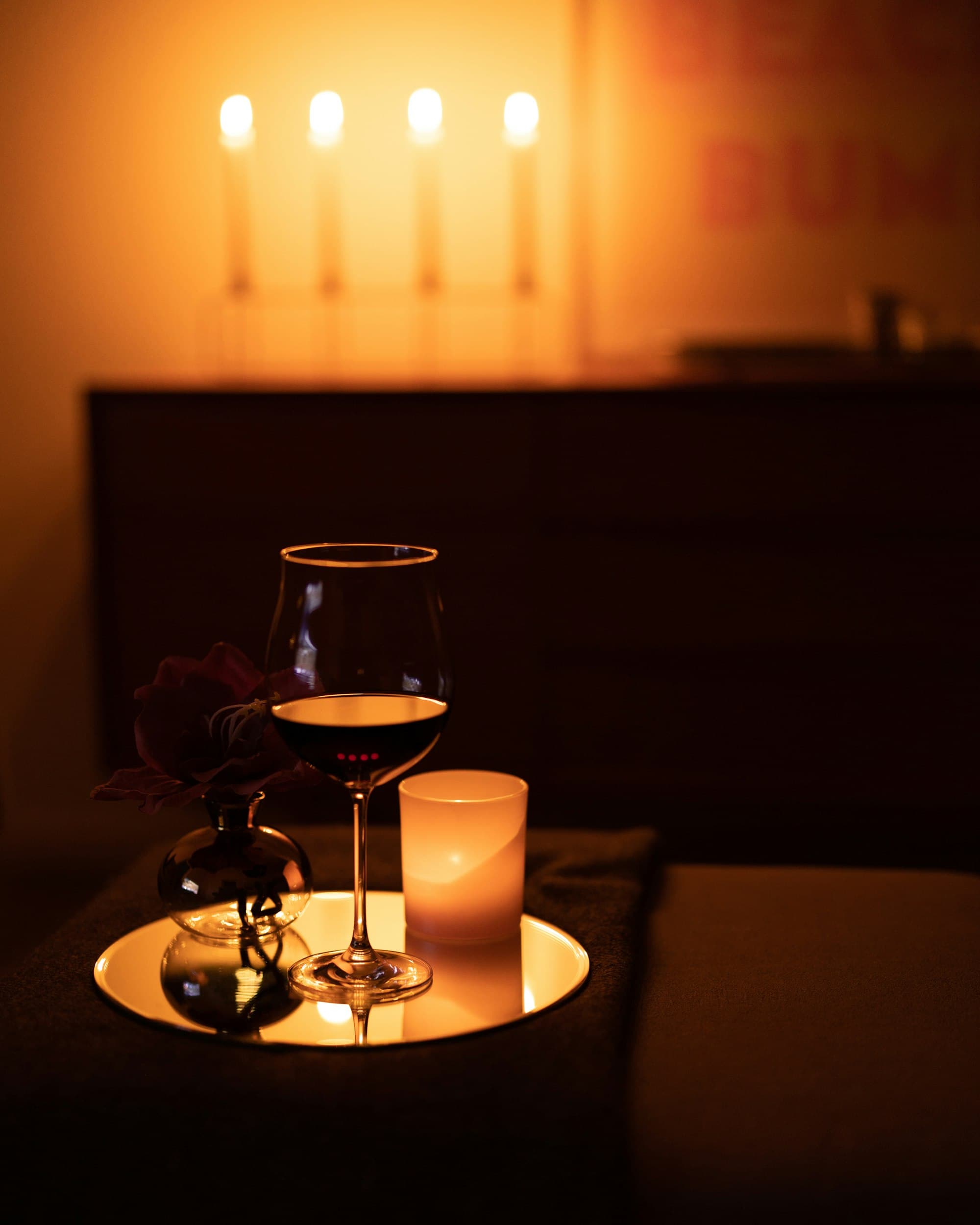 Two glasses and candlelight in a warmly lit private room